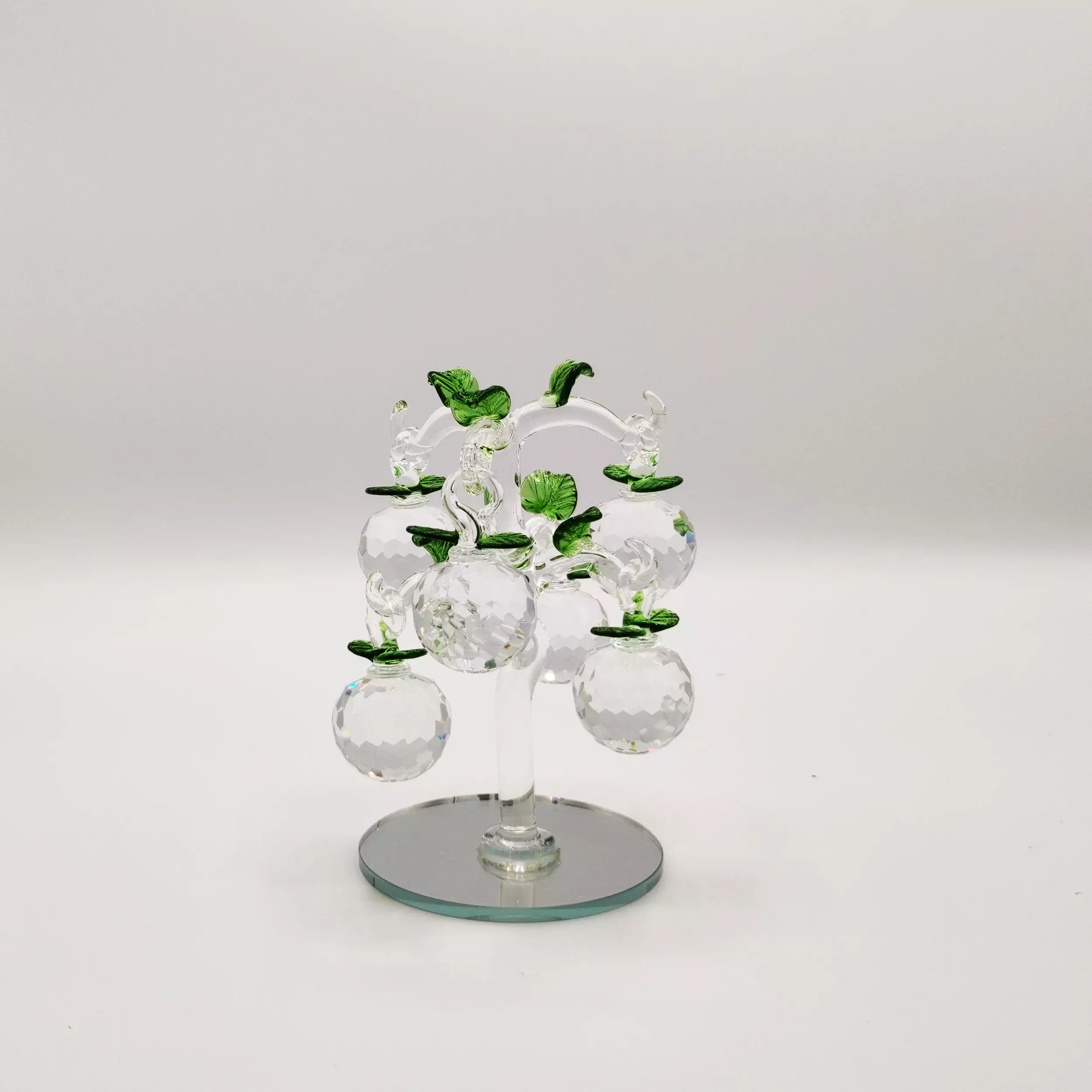Clear glass apple tree ornament with green leaf accents.