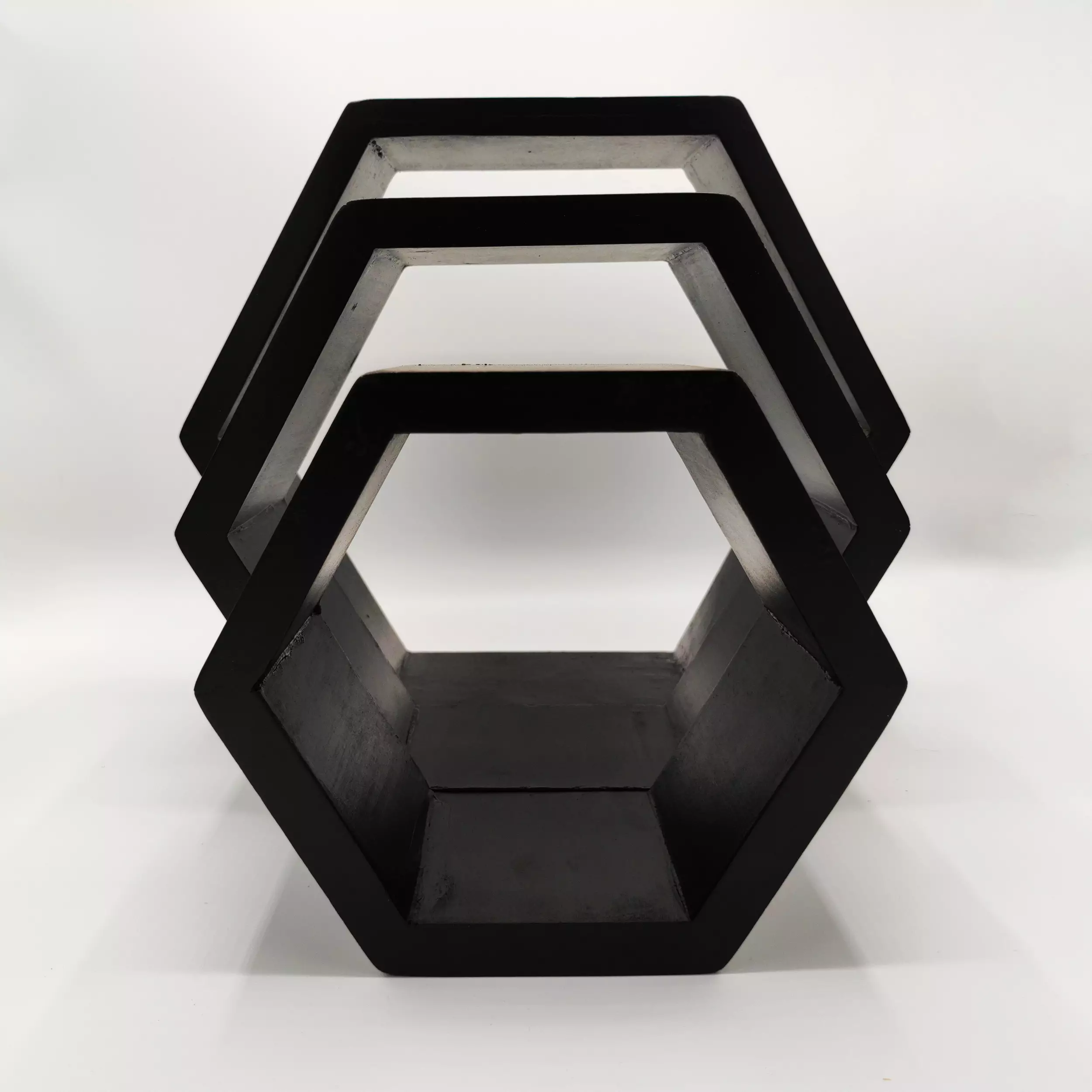 Black hexagonal wood shelf with three tiers.