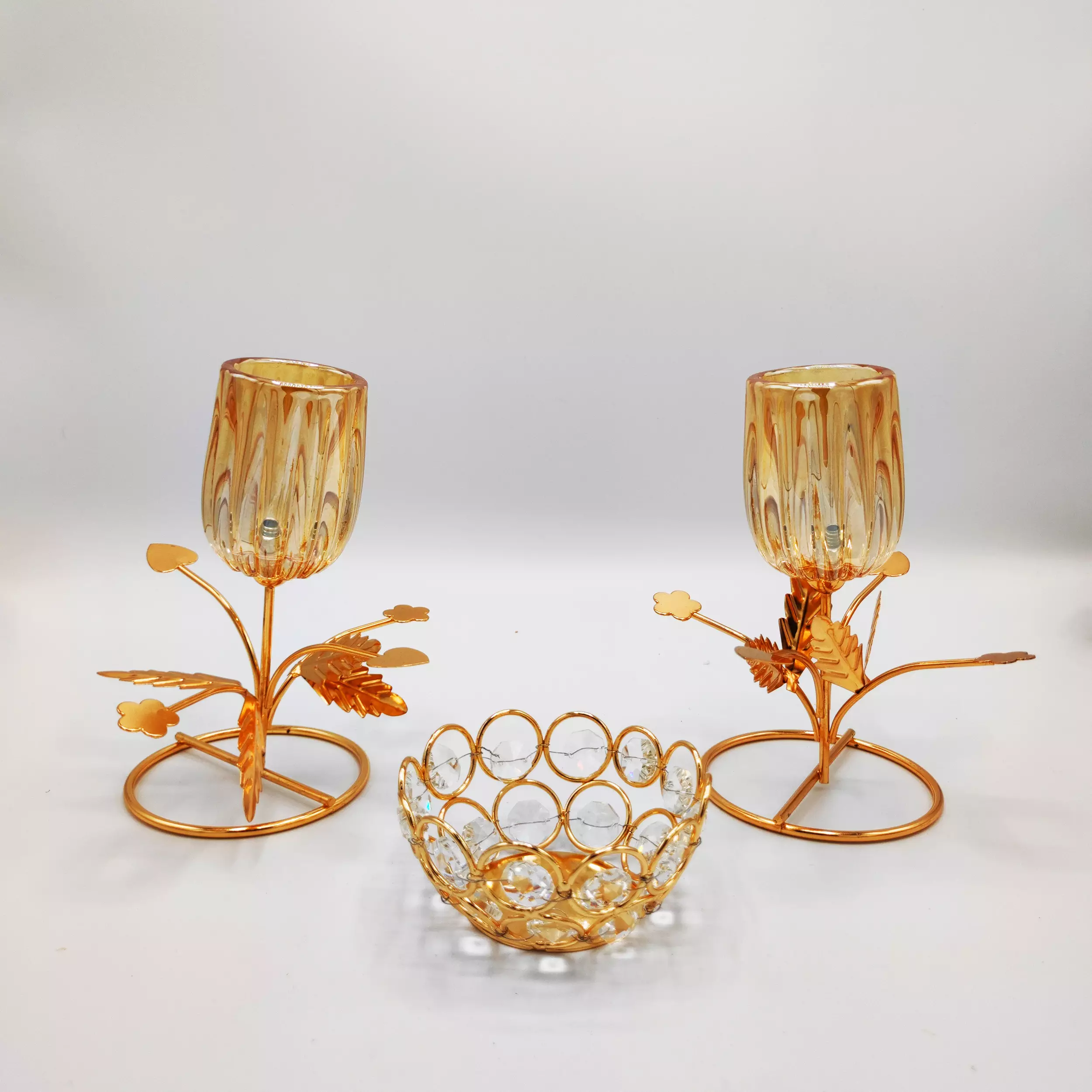 Gold metal candle stand set including two metal candle stand with amber textured glass candle cups.