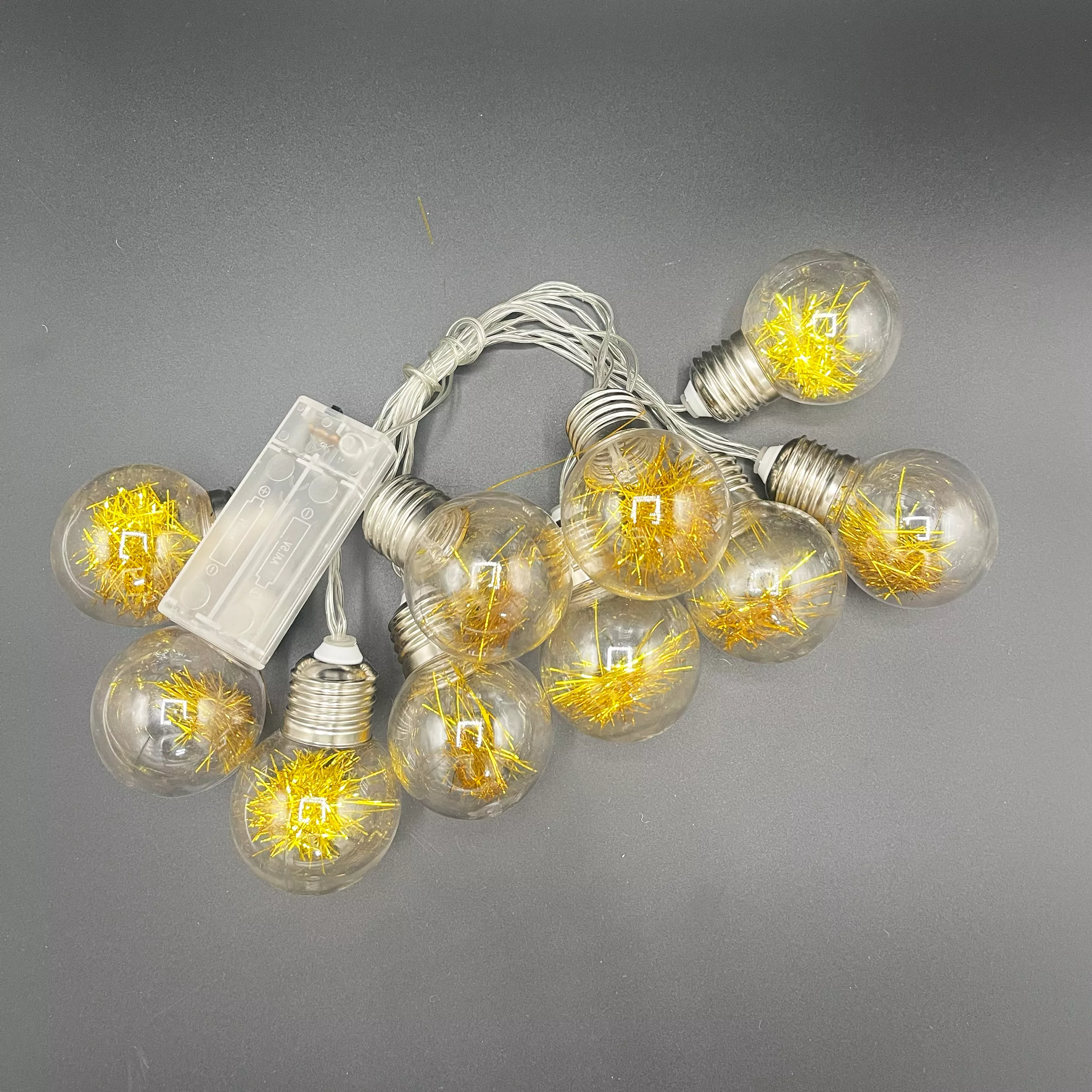 LED lighted lanterns with spherical bulbs on a gray surface.
