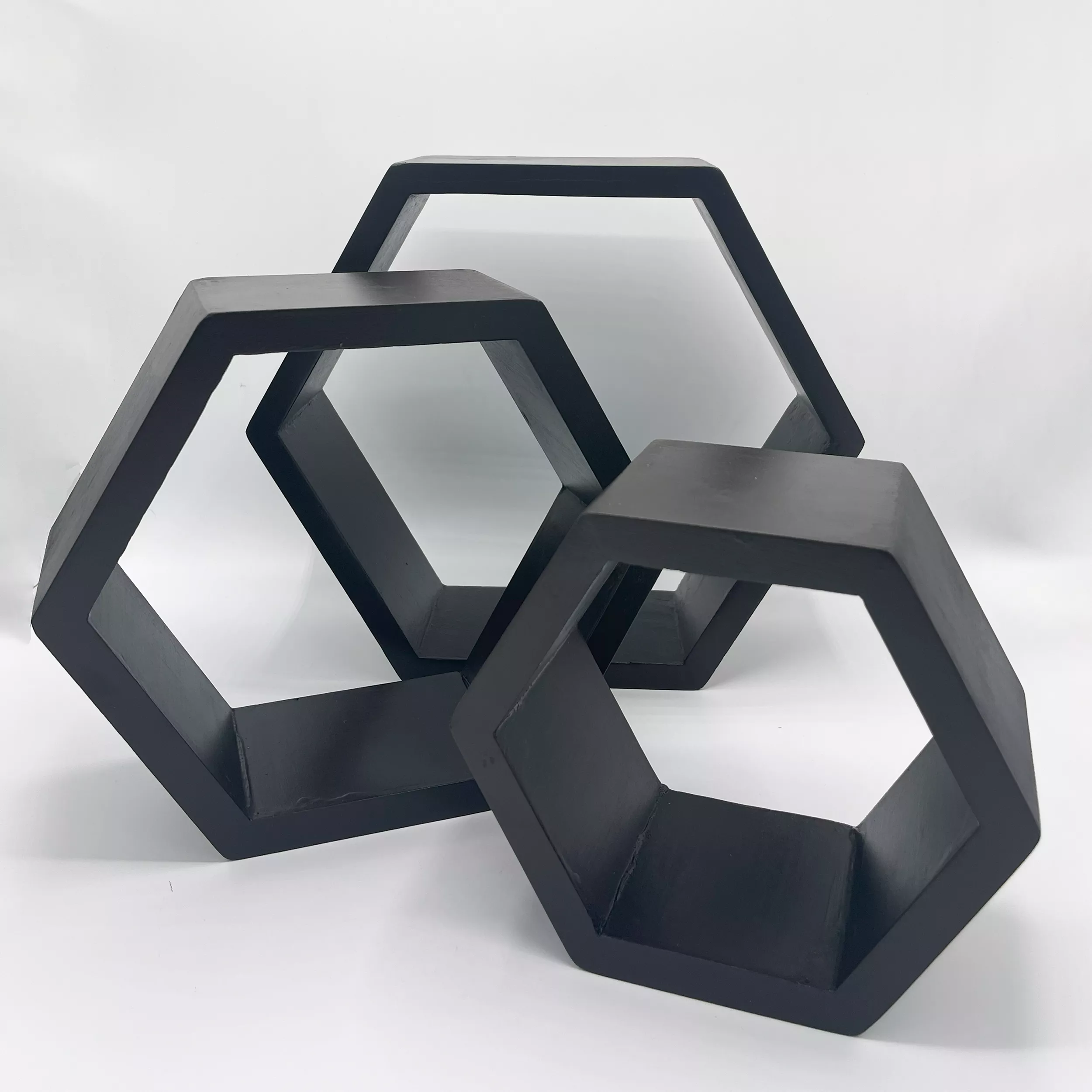 Hexagonal: Three black Wall Shelves hexagon wood shelves stacked diagonally.