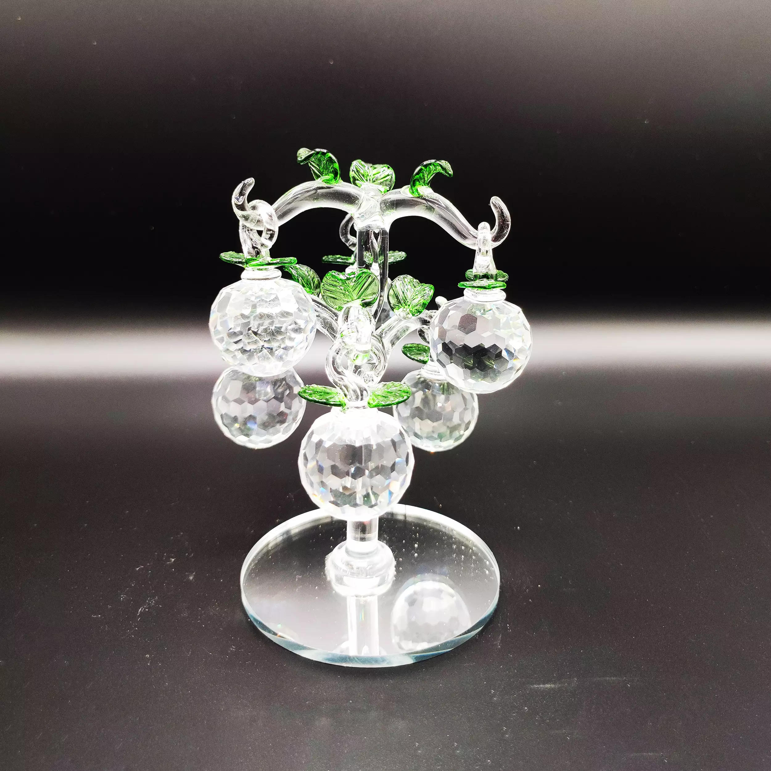 Glass apple tree sculpture with crystal fruits and green leaves